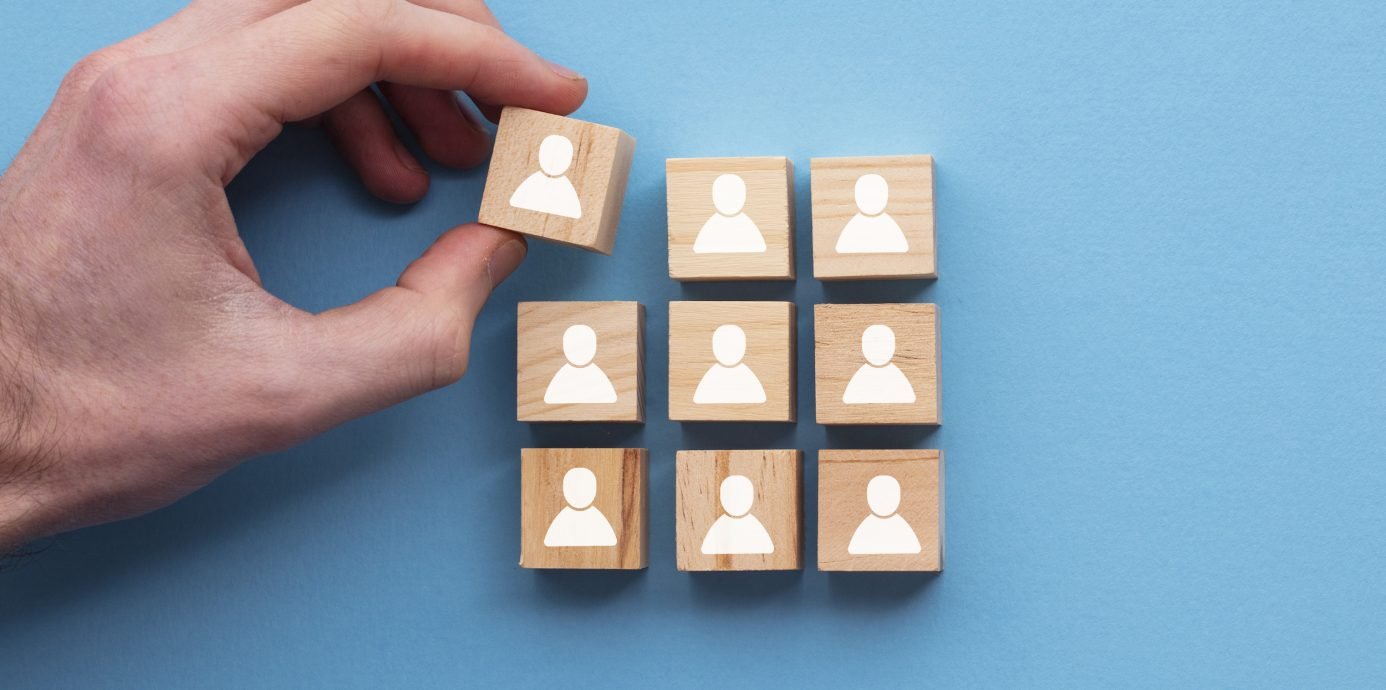 Person stacking blocks with people icons